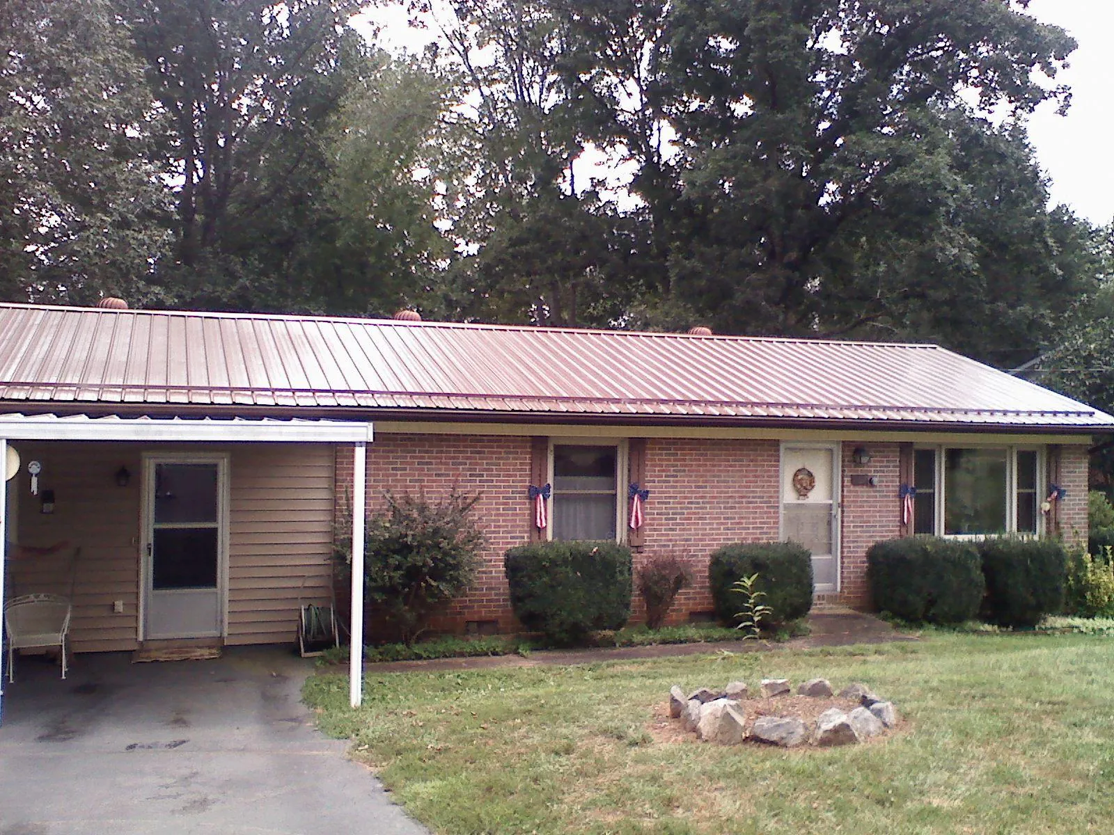 Bronze metal roof and carport on a brick ranch home — Roof Repair work by our crew in Clear Lake