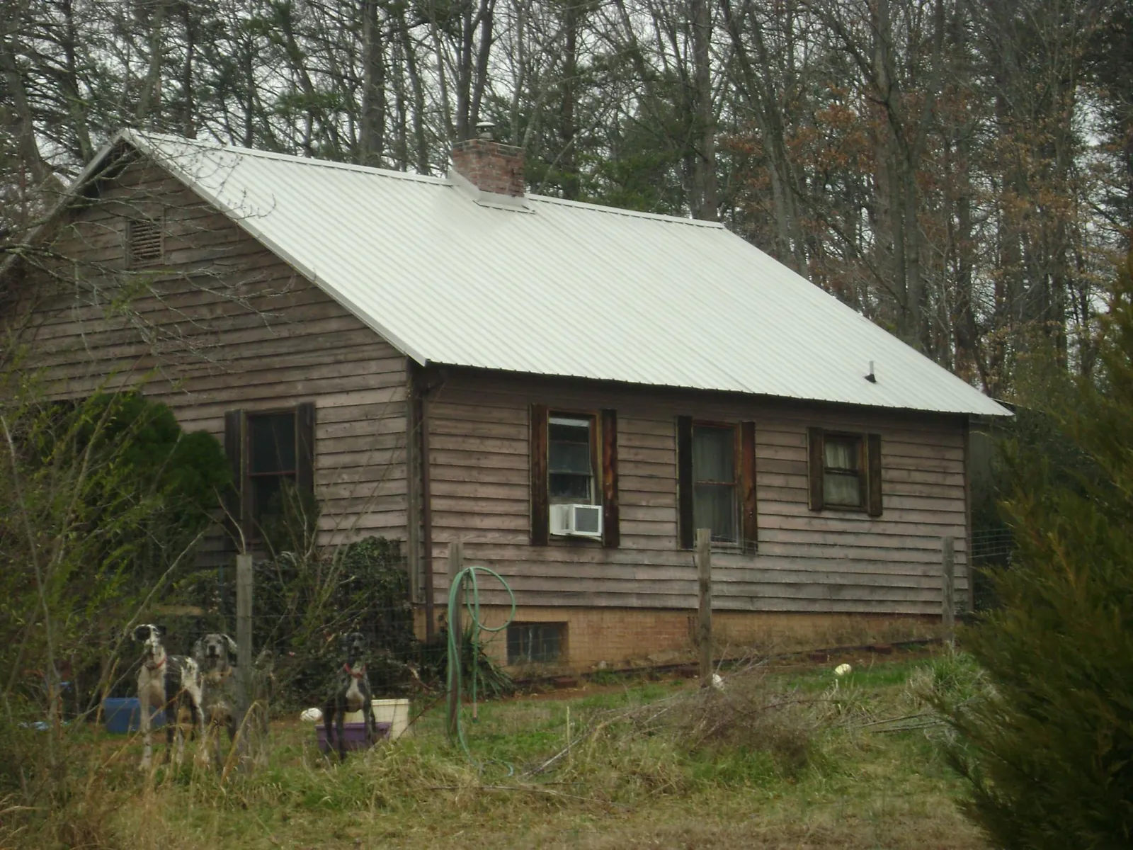 White metal roof on an old wood sided farmhouse, from a Metal Roof Installation job in Clear Lake